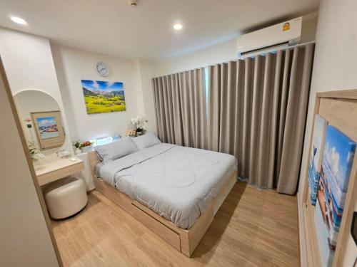 a small bedroom with a bed and a television at Phyll Condo Room in Wichit in Ban Rangeng