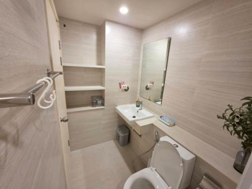 a bathroom with a toilet and a sink and a mirror at Phyll Condo Room in Wichit in Ban Rangeng