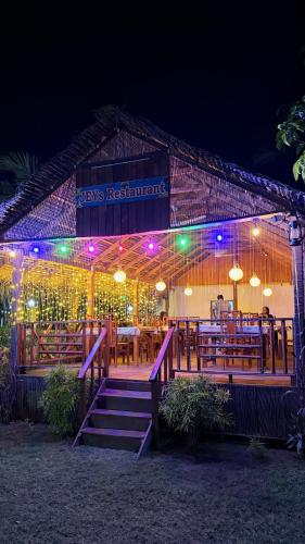 a restaurant with tables and lights at night at JEYs Place in Nilaveli