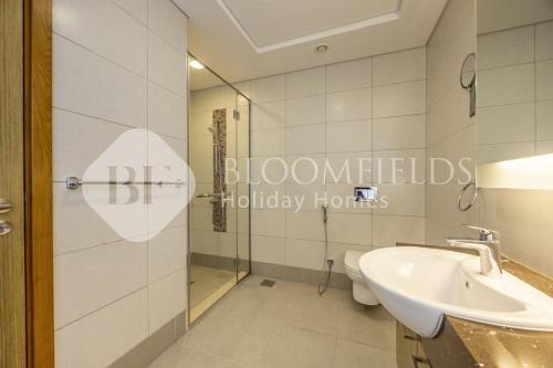 a bathroom with a shower and a sink and a toilet at Bloomfields 2BR in Lamar Raha Beach in Abu Dhabi