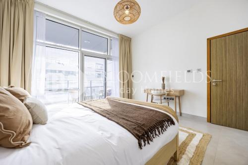 a bedroom with a bed and a large window at Bloomfields 2BR in Lamar Raha Beach in Abu Dhabi