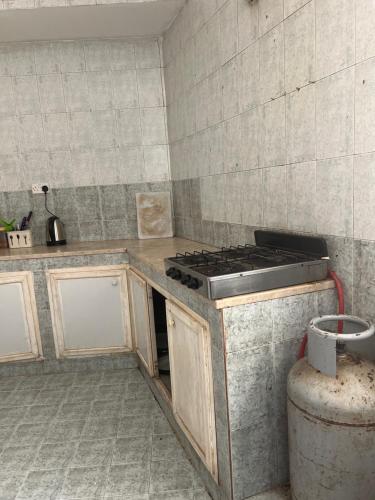 a kitchen with a stove top oven in a room at Turkish Muscat hostel in Muscat