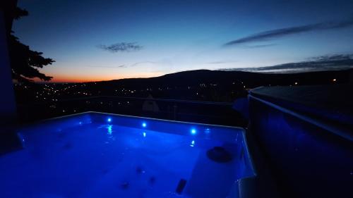 a night view of a swimming pool on top of a building at Hillside Cottage in Pécs