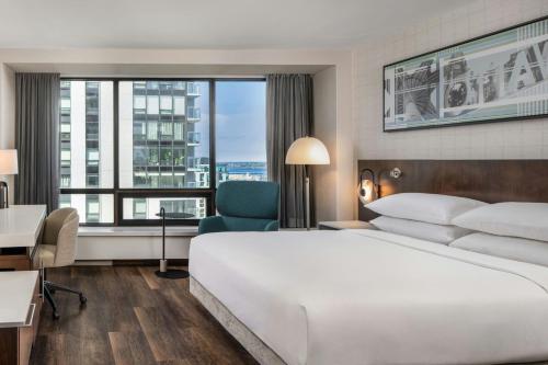 a hotel room with a bed and a desk and a window at Delta Hotels by Marriott Ottawa City Centre in Ottawa