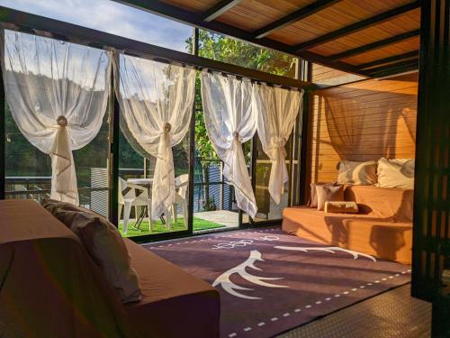 a bedroom with a bed and a large window at FREESCAPE Quiet Reset - Lakeside Mountainview in Cavinti