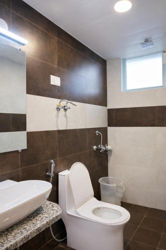 a bathroom with a toilet and a sink at Hotel Old Manali with Balcony, Mountain and River View in Manāli