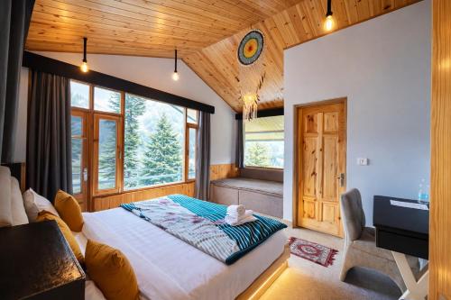 a bedroom with a large bed and a window at Hotel Old Manali with Balcony, Mountain and River View in Manāli