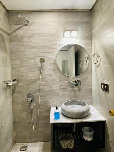 a bathroom with a sink and a shower with a mirror at Three Trees Hotel Islamabad in Islamabad