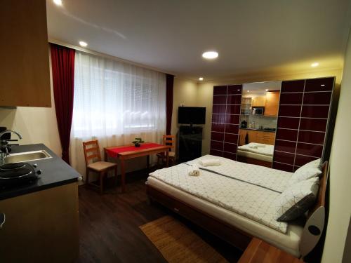 a small room with a bed and a small kitchen at Napolá apartman in Balatonalmádi