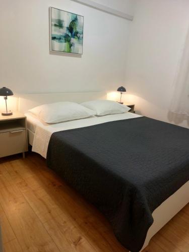 a bedroom with a bed and two nightstands and two lamps at Tangerine Apartment in Rabac