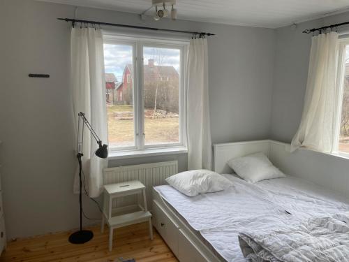 a bedroom with a white bed and a window at Lissmogården in Leksand