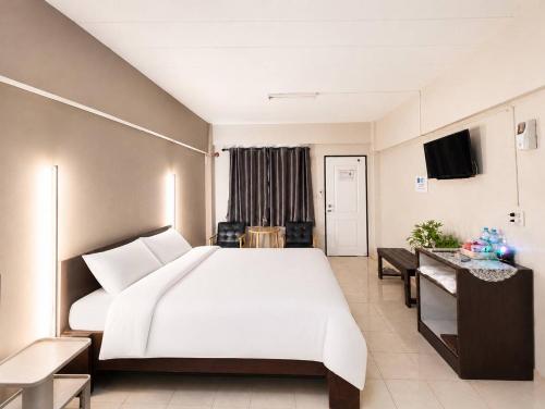 a bedroom with a large white bed and a table at Hotel M Rojana Ayutthaya in Ban Sang