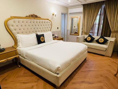 a bedroom with a large white bed and a couch at Three Trees Hotel Islamabad in Islamabad