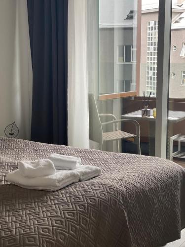 a bedroom with a bed with two towels on it at Cozy Central Reykjavik in Reykjavík
