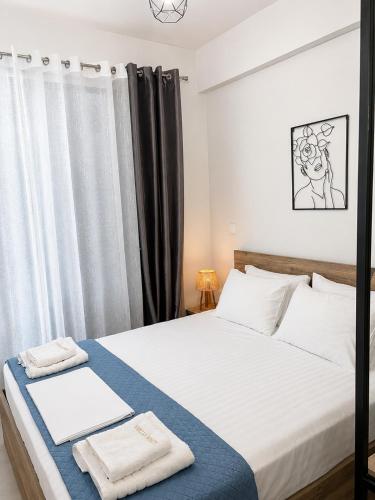a bedroom with a large white bed with black curtains at Aelia Blu 1 in Ofrínion