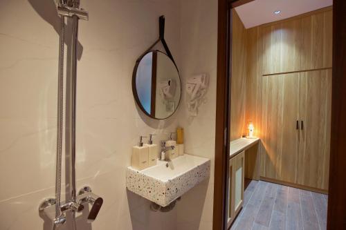 a bathroom with a sink and a mirror on the wall at Emlyhome Hanriver in Danang