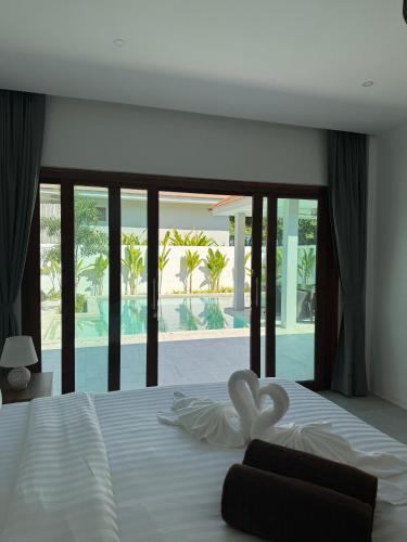 a bedroom with a white bed with a large window at Villa Palm Sip Sam in Ko Phangan