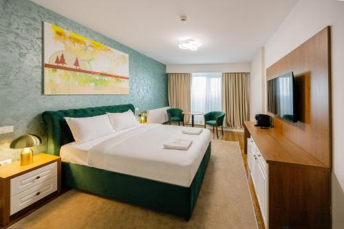 a hotel room with a bed and a television at In Grand Hotel & SPA in Bucharest