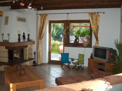 a living room with a couch and a tv at Spacious holiday home in Przesieka with sauna in Przesieka