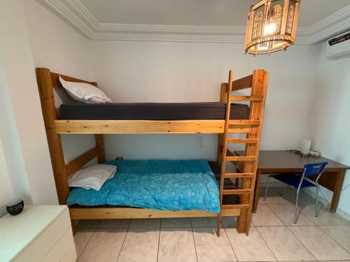 a bedroom with a bunk bed and a desk at Habibi-Danydan La Chebba in Chebba