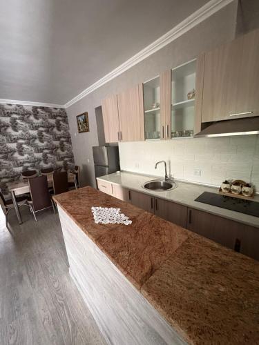 a kitchen with a counter and a sink and a table at fam rest in Garni