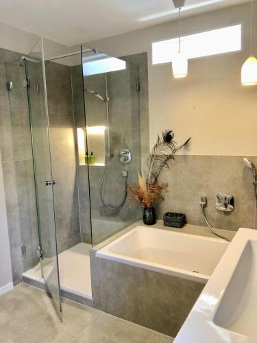 a bathroom with a tub and a glass shower at Haus SandRast in Westerland