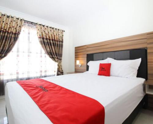 a bedroom with a large bed with a red blanket at RedDoorz near UGM 3 in Yogyakarta