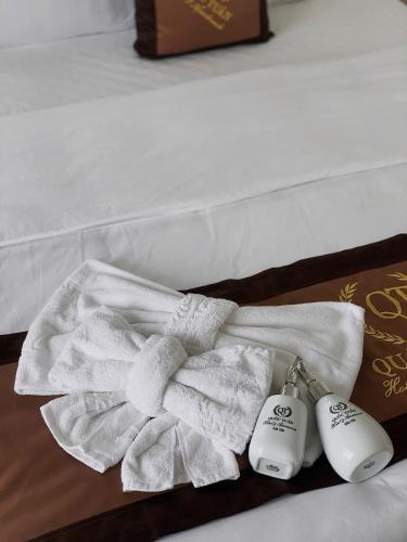 a pile of towels on a bed with two meters at Hotel QUỐC TUẤN in Ban Ay Dlă (2)