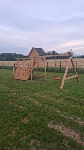 a wooden playground in a field of grass at Apartmaji Baznik Čatež in Brežice