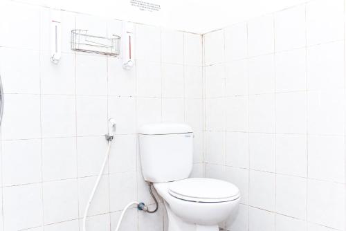 a white bathroom with a toilet and a shower at RedDoorz near UGM 3 in Yogyakarta