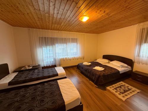 a bedroom with two beds and a wooden ceiling at Gold Fayen House Cheile Turului in Tureni