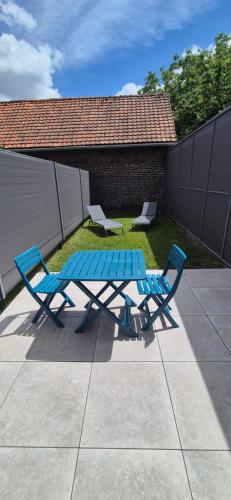 two blue chairs and a picnic table on a patio at Studio between city and countryside in Lompret