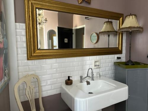 a bathroom with a sink and a mirror and a chair at Chez Anne in Fécamp