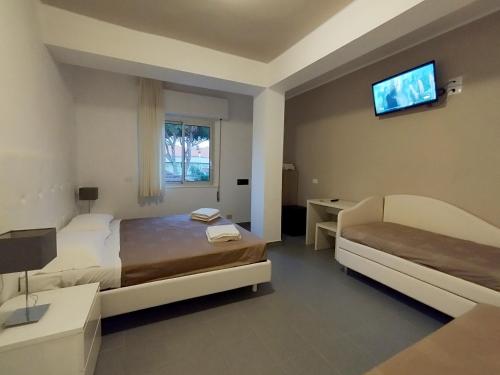 a bedroom with two beds and a television on the wall at Hotel Desire' in Riccione