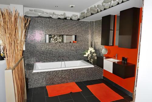 a bathroom with a white tub and red tiles at Villa Mare Monti in Lumio