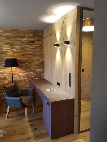 a room with a desk and a chair and a wall at Hotel Dein Franz - Bistro, Kaffeebar & Outdoor-Lounge - in Bad Füssing