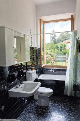 a bathroom with a toilet and a sink and a tub at Ortensia Apartment for 4 near Lake Como and Lugano in Lanzo dʼIntelvi