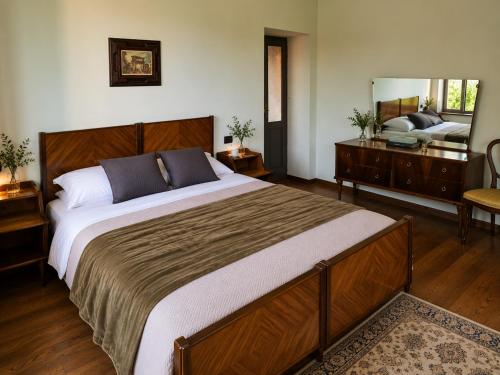 a bedroom with a large bed and a mirror at Ortensia Apartment for 4 near Lake Como and Lugano in Lanzo dʼIntelvi