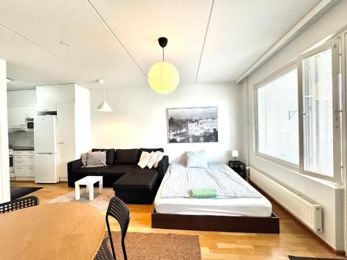 a living room with a couch and a table at Warm and cozy one-bedroom & Sauna in Vantaa