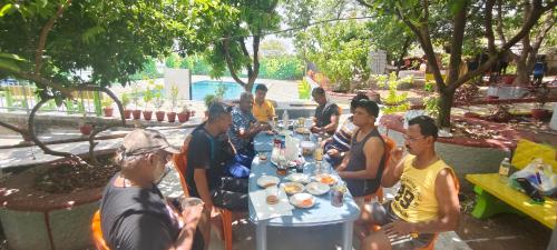 a group of people sitting around a table at Harshangi Resort wada in Wada