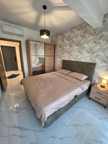a bedroom with a large bed and a mirror at Eclipse Luxury Suite in Šušanj