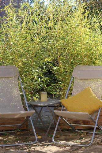 two chairs and a table with a yellow pillow at Alegria Studios - en Provence - Piscine avec vue - Terrasse privative in Aups
