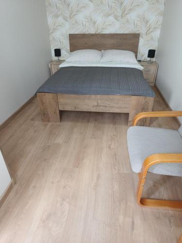 a bedroom with a bed and a wooden floor at Manta Apartamenty in Sianozety