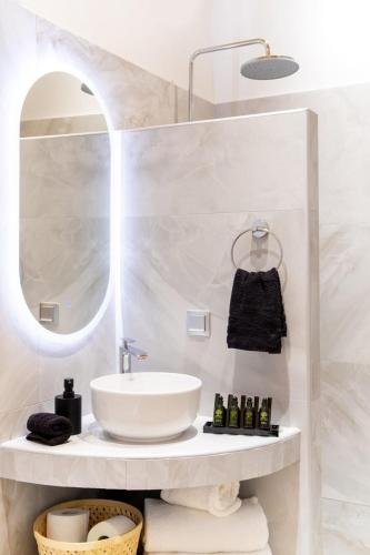 a bathroom with a sink and a mirror at Gaia Trikeri Suites in Ayía Kiriakí