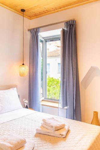 a bedroom with a bed and a window at Gaia Trikeri Suites in Ayía Kiriakí
