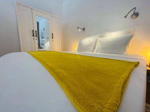 a white bed with a yellow blanket on it at Alegria Studios - en Provence - Piscine avec vue - Terrasse privative in Aups