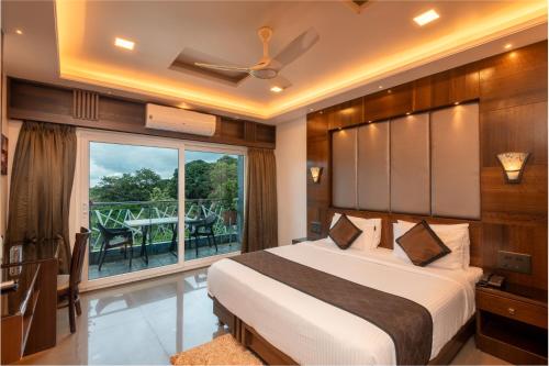 a bedroom with a bed and a balcony at Hotel Altitude Coorg in Madikeri