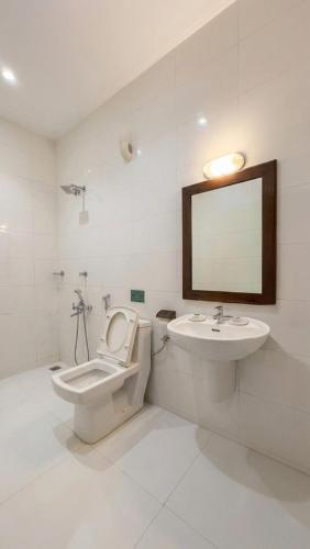 a bathroom with a toilet and a sink and a mirror at Samudra heritage in Cochin