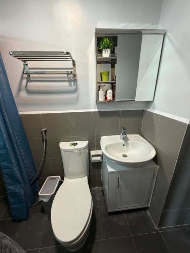 a bathroom with a white toilet and a sink at Endless Summer Seafront - 1BR Beach Resort Condo in San Juan