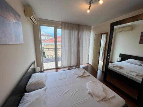 a bedroom with two beds and a large window at Casa 18 in Sveti Vlas